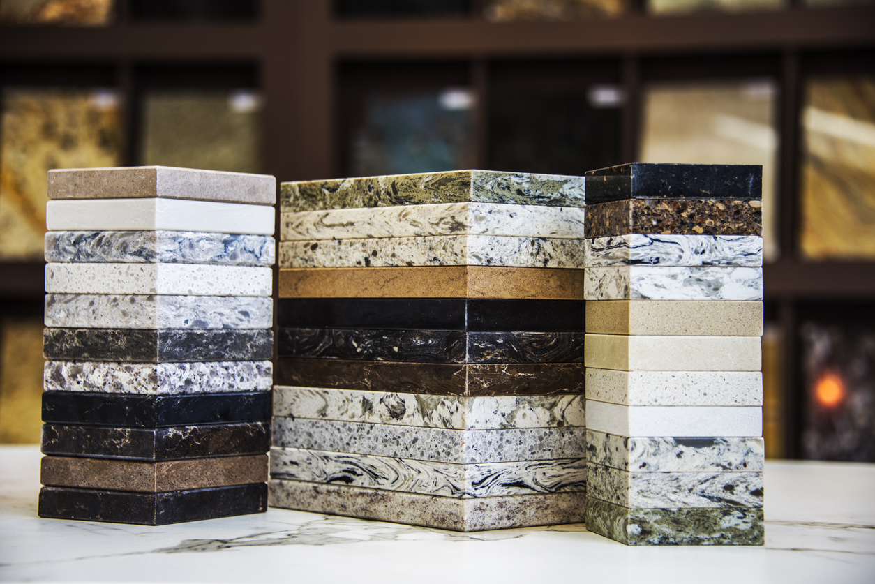 The image shows a close up of natural stone countertop samples to explain the benefits of natural stone countertops.